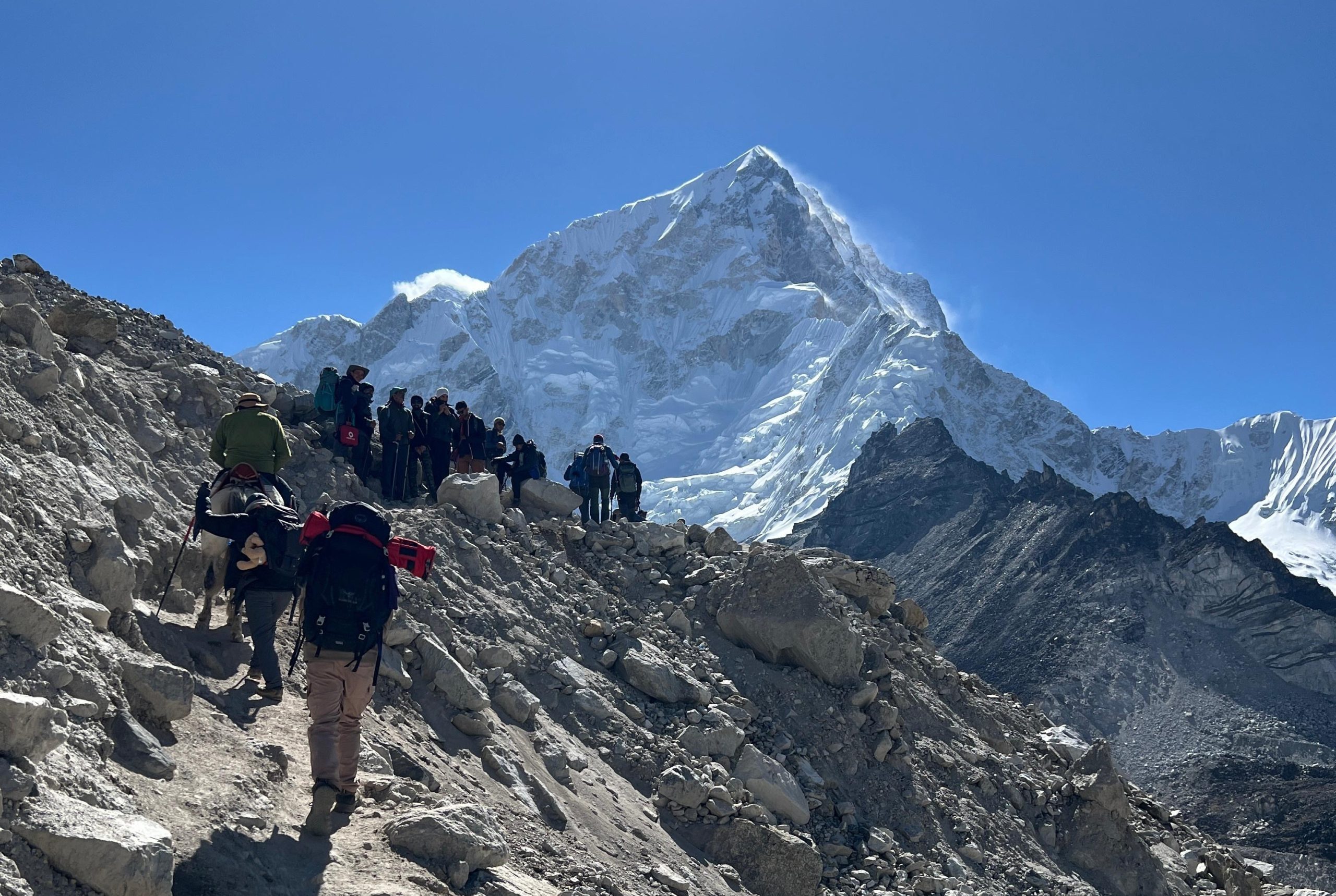 Trekker climbing steep Himalayan trail with snow peaks