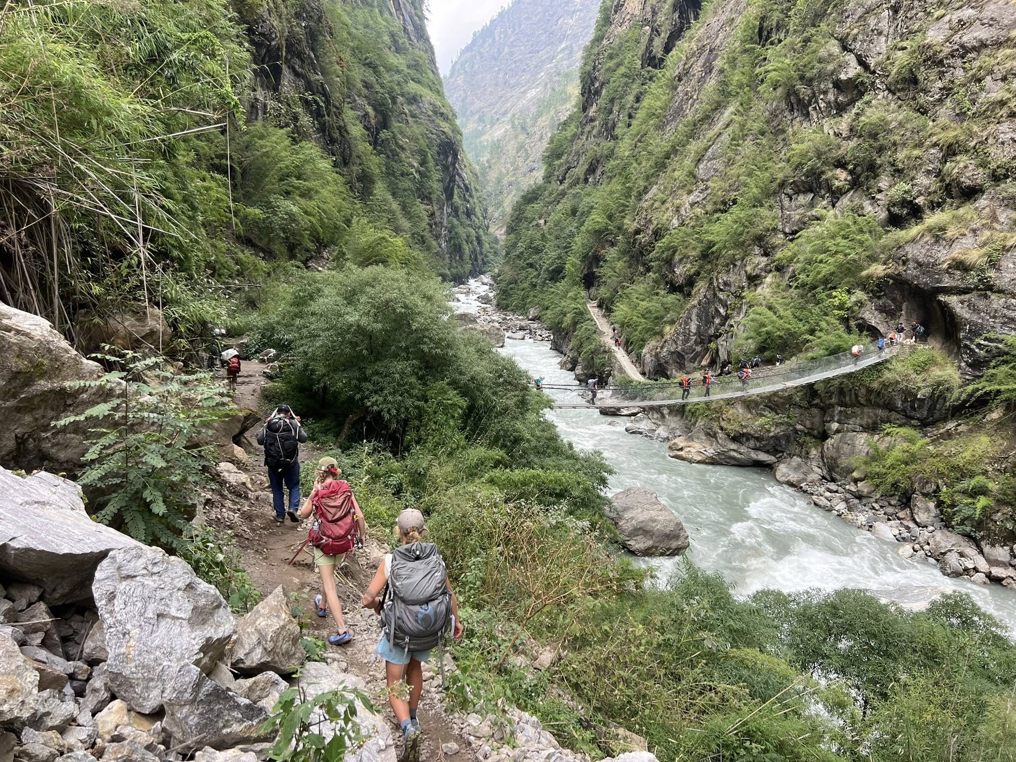trekkers crossing suspension bridge on their way to jagat from machha khola en-route manaslu circuit trek