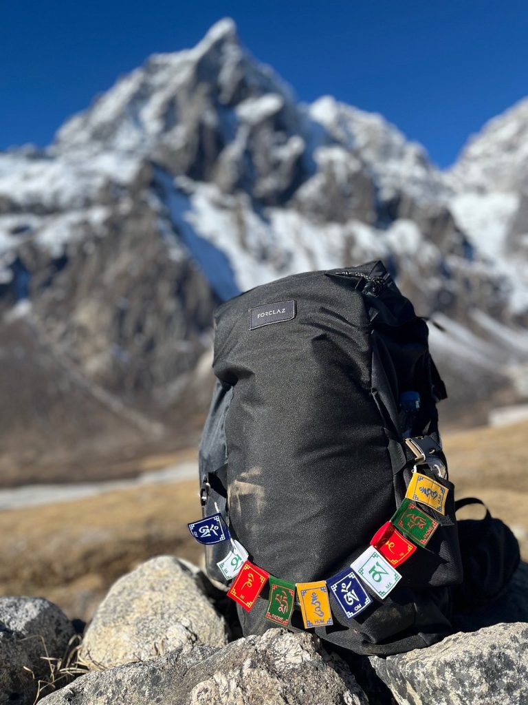 A trekker preparing a backpack while overlooking the Himalayan mountain range.